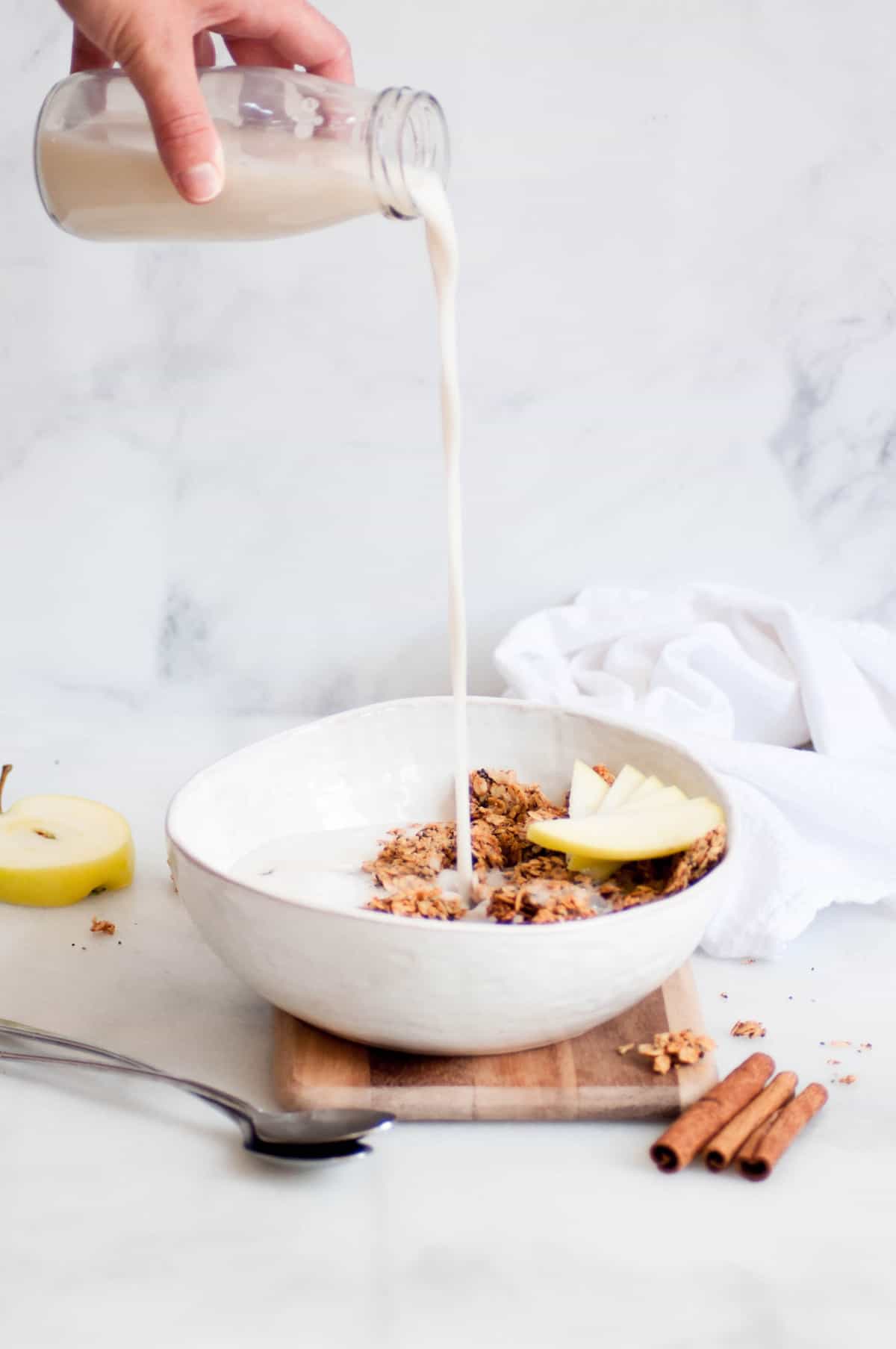 milk pouring into bowl with granola