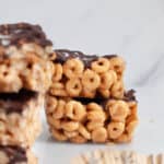 Stack of no-bake peanut butter cereal bars with a chocolate drizzle