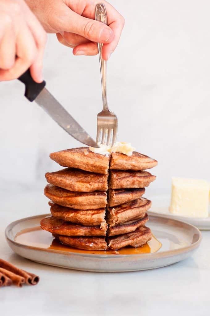 cutting into stack of oatmeal blender pancakes