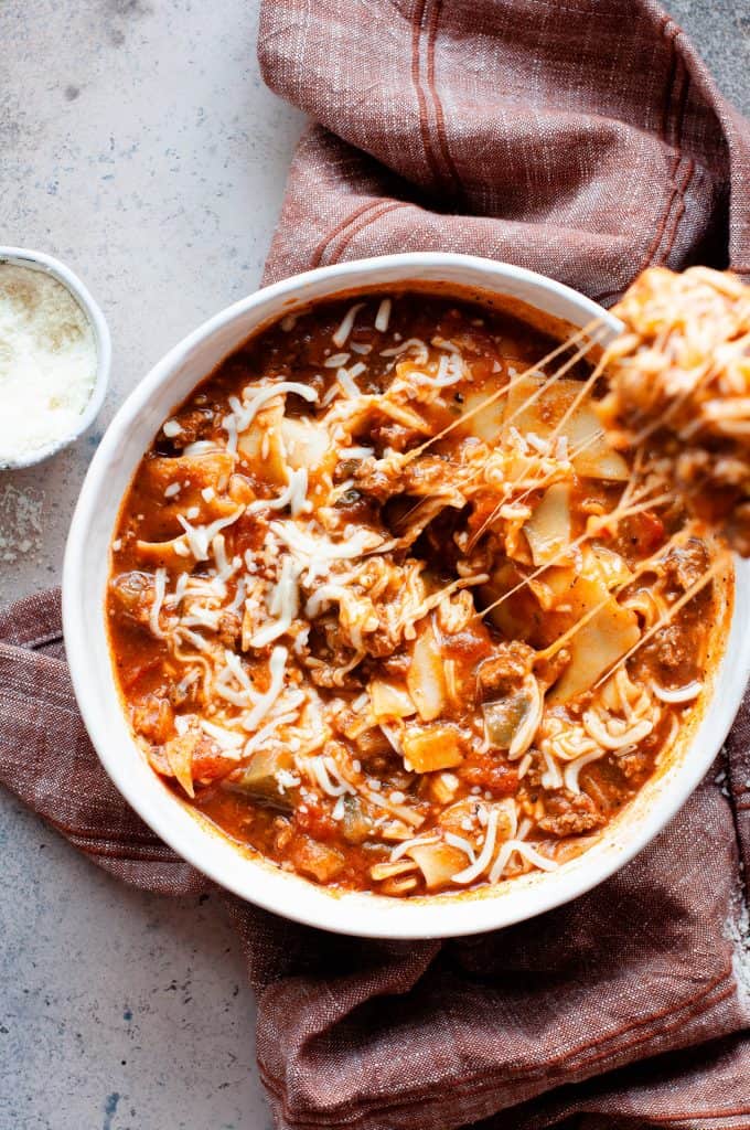 lasagna soup in bowl with cheese pull