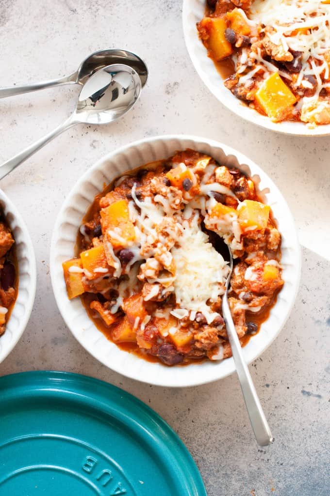 butternut squash chili in bowl with cheese