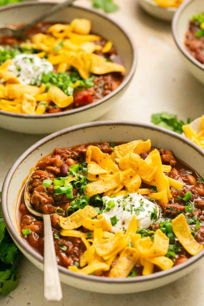 beef chili with cheese and fritos in bowls