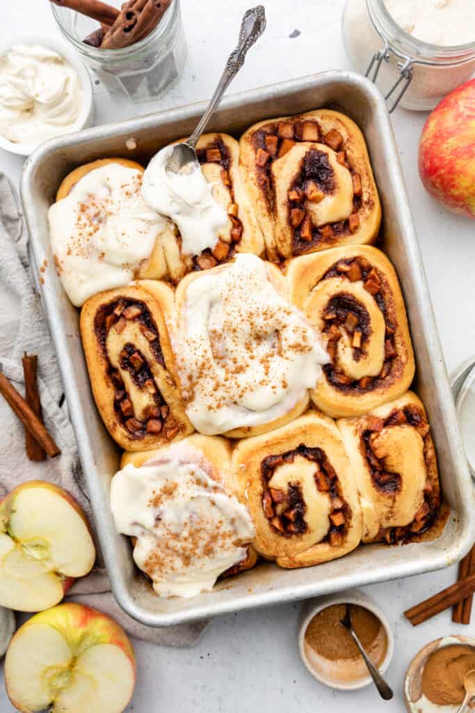 apple cinnamon rolls in pan with icing