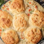 Chicken pot pie with crispy golden biscuits on top in a skillet.