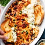 dipping crostini in garlic bread dip