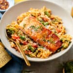 salmon orzo skillet on tan plate with spoon