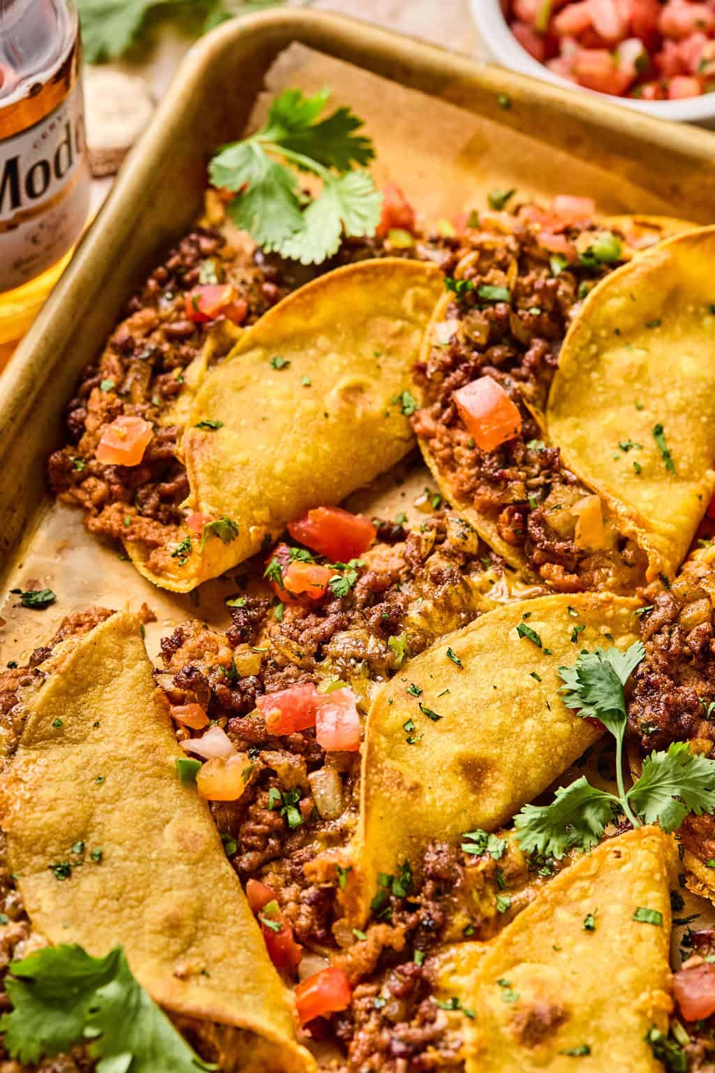 oven baked beef tacos on baking sheet.