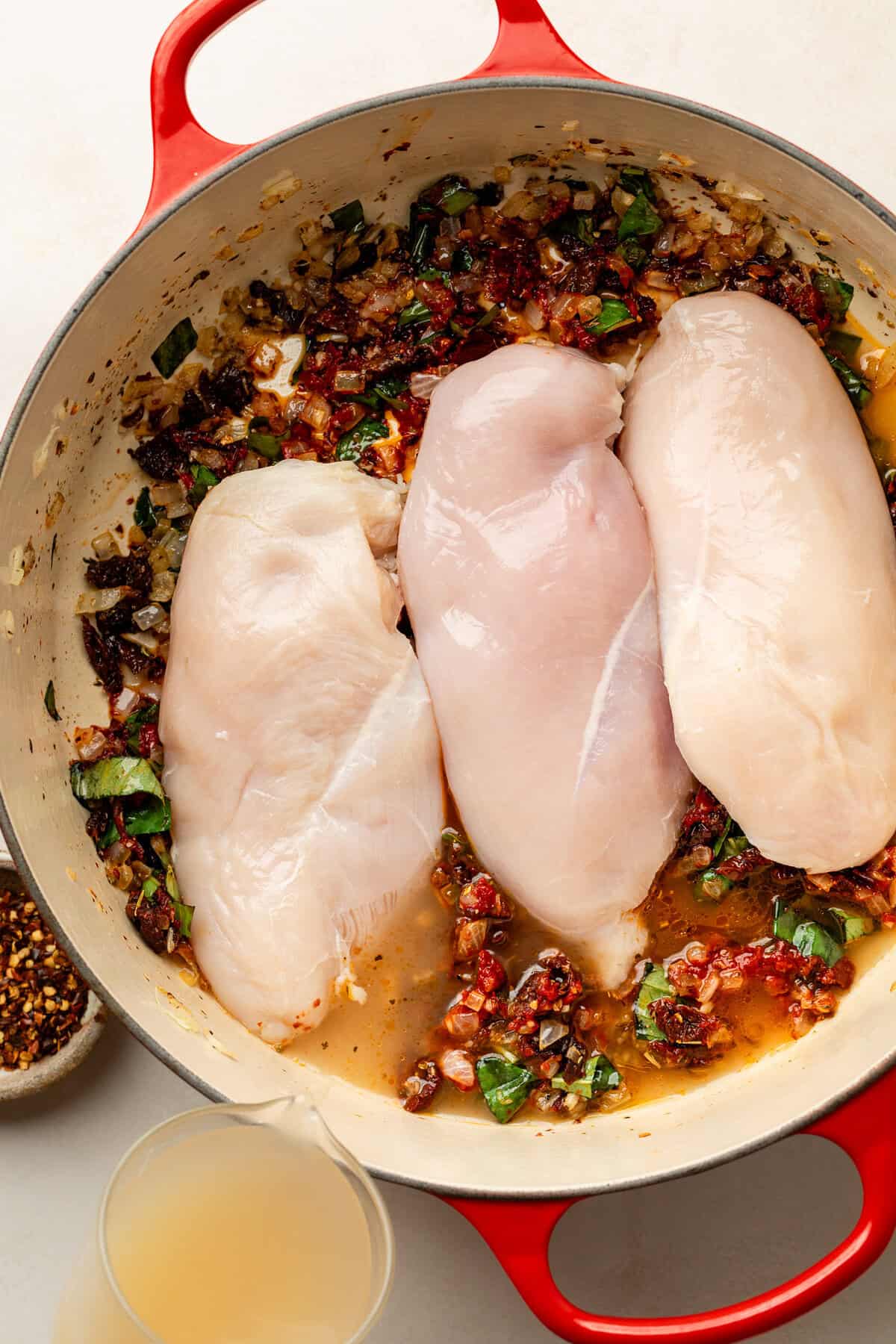 Chicken breasts on top of ingredients in dutch oven
