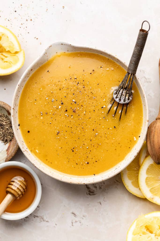 All dressing ingredients in bowl with whisk