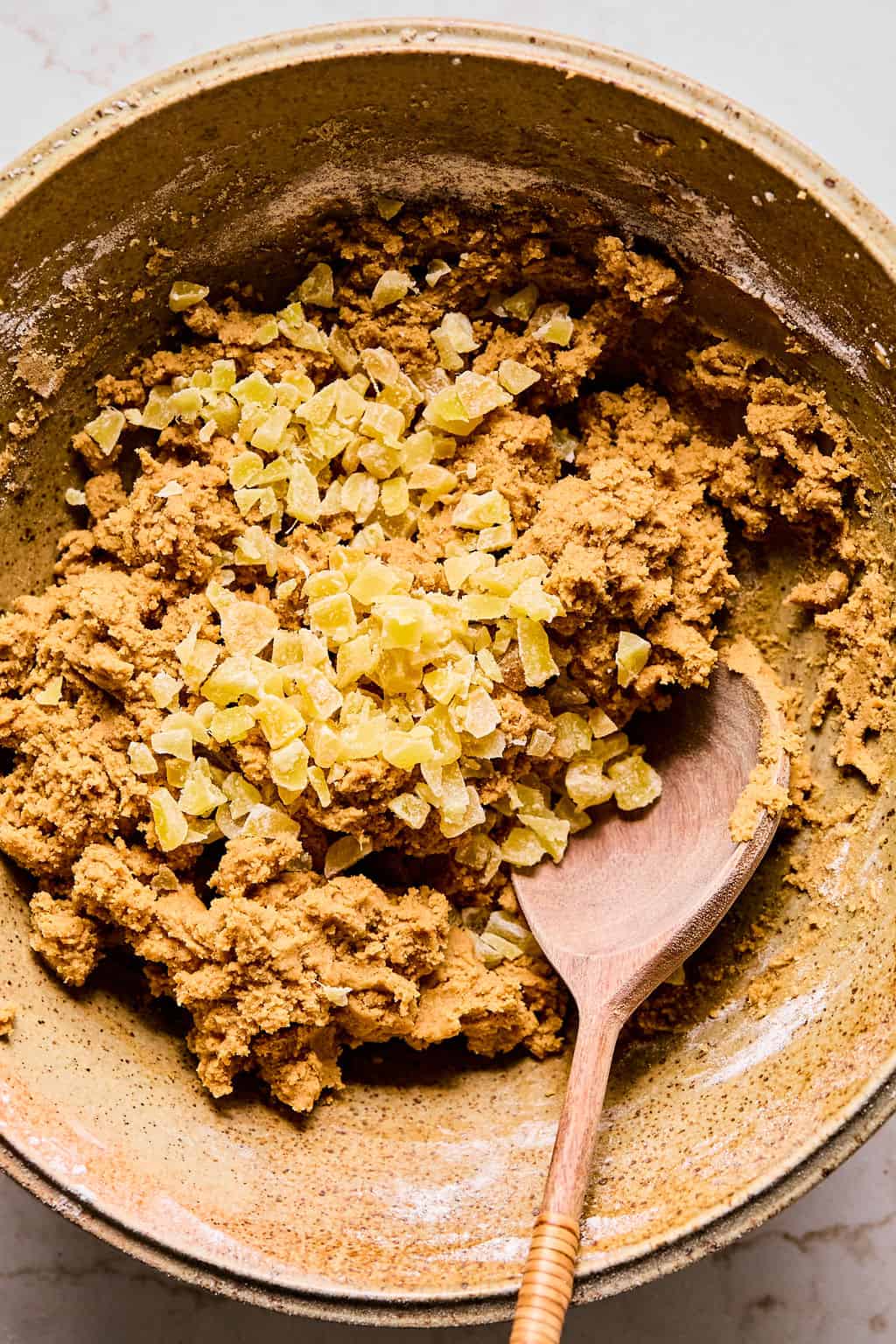 Adding crystalized ginger to bowl with cookie dough