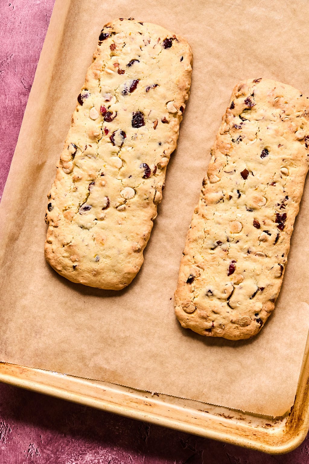 Full baked Almond Cranberry Biscotti on baking sheet