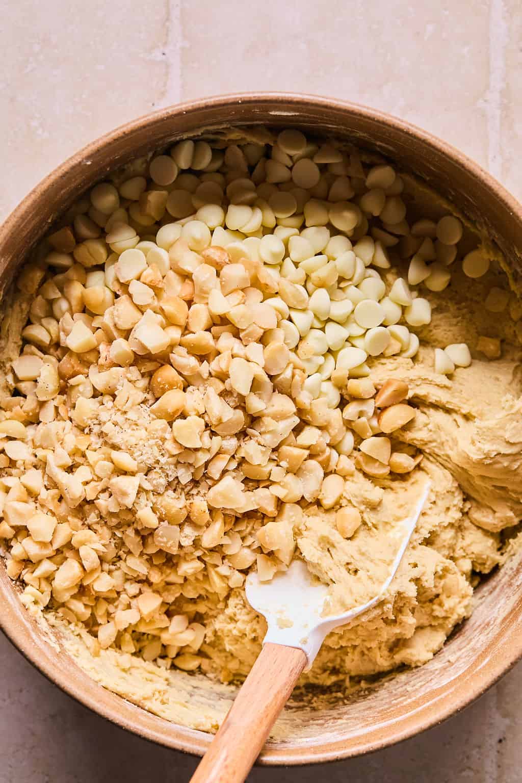 White chocolate chips and macadamia nuts mixed into bowl