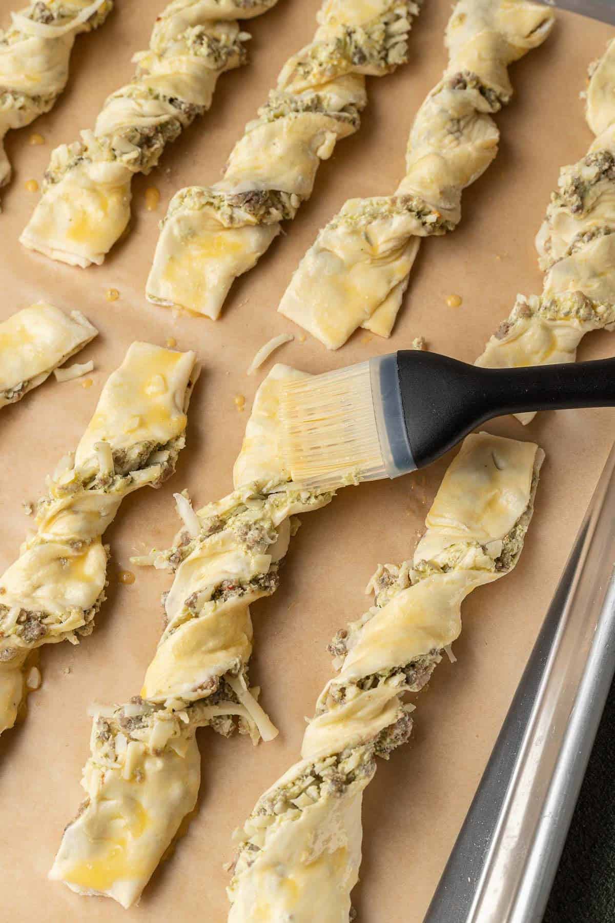 Brushing each pastry with egg wash