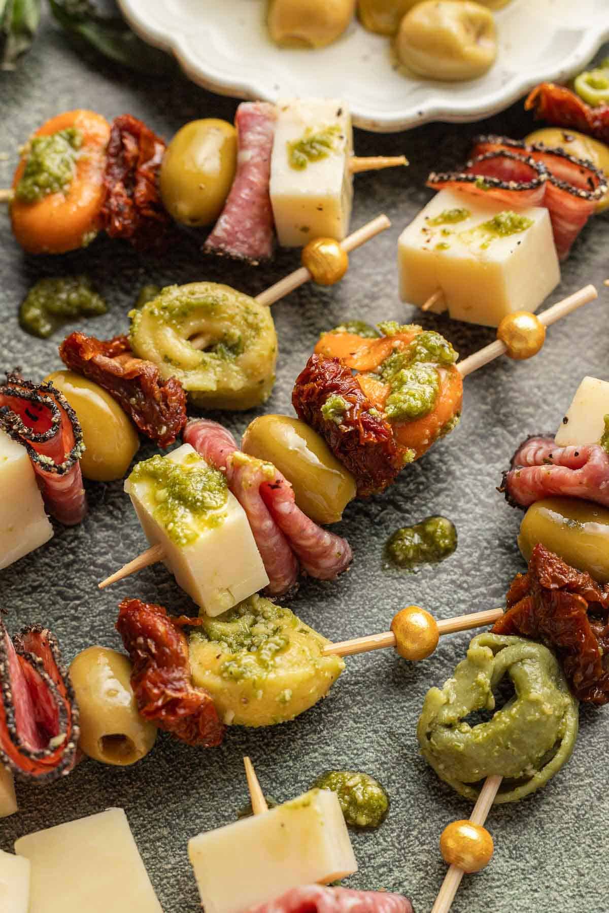 Pesto Tortellini Bites, cheese, salami, olive sundried tomato and tortellini on a toothpick