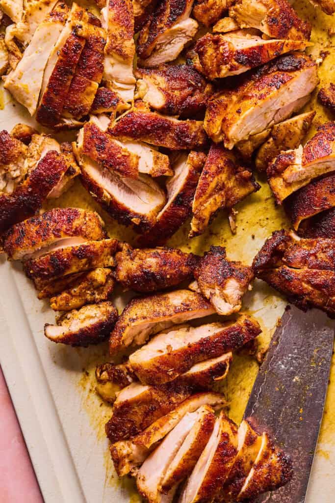 Chicken thighs sliced on cutting board