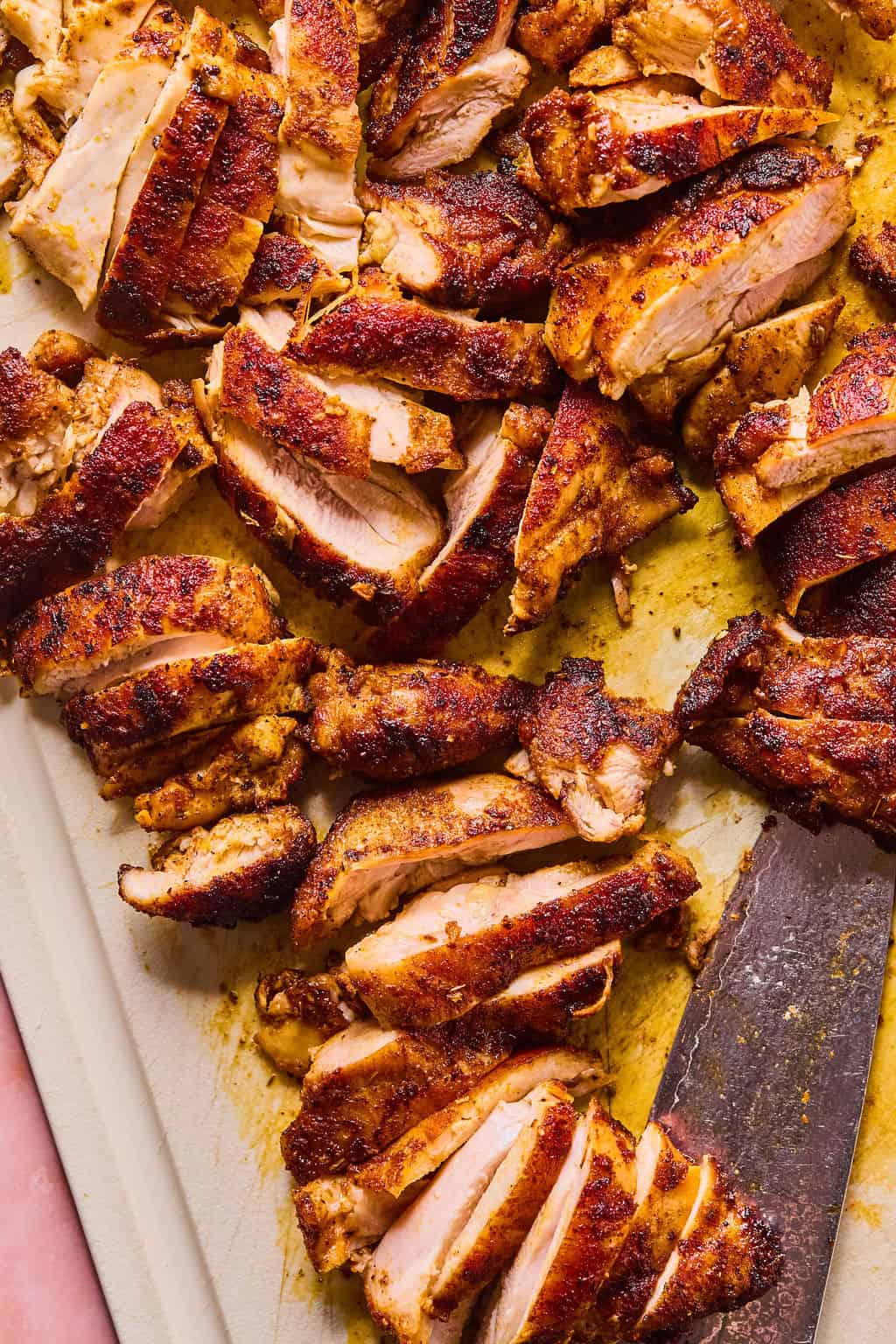 Chicken thighs sliced on cutting board