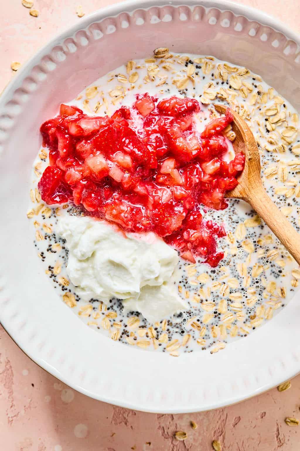 Strawberries, yogurt, maple syrup, and milk added to bowl