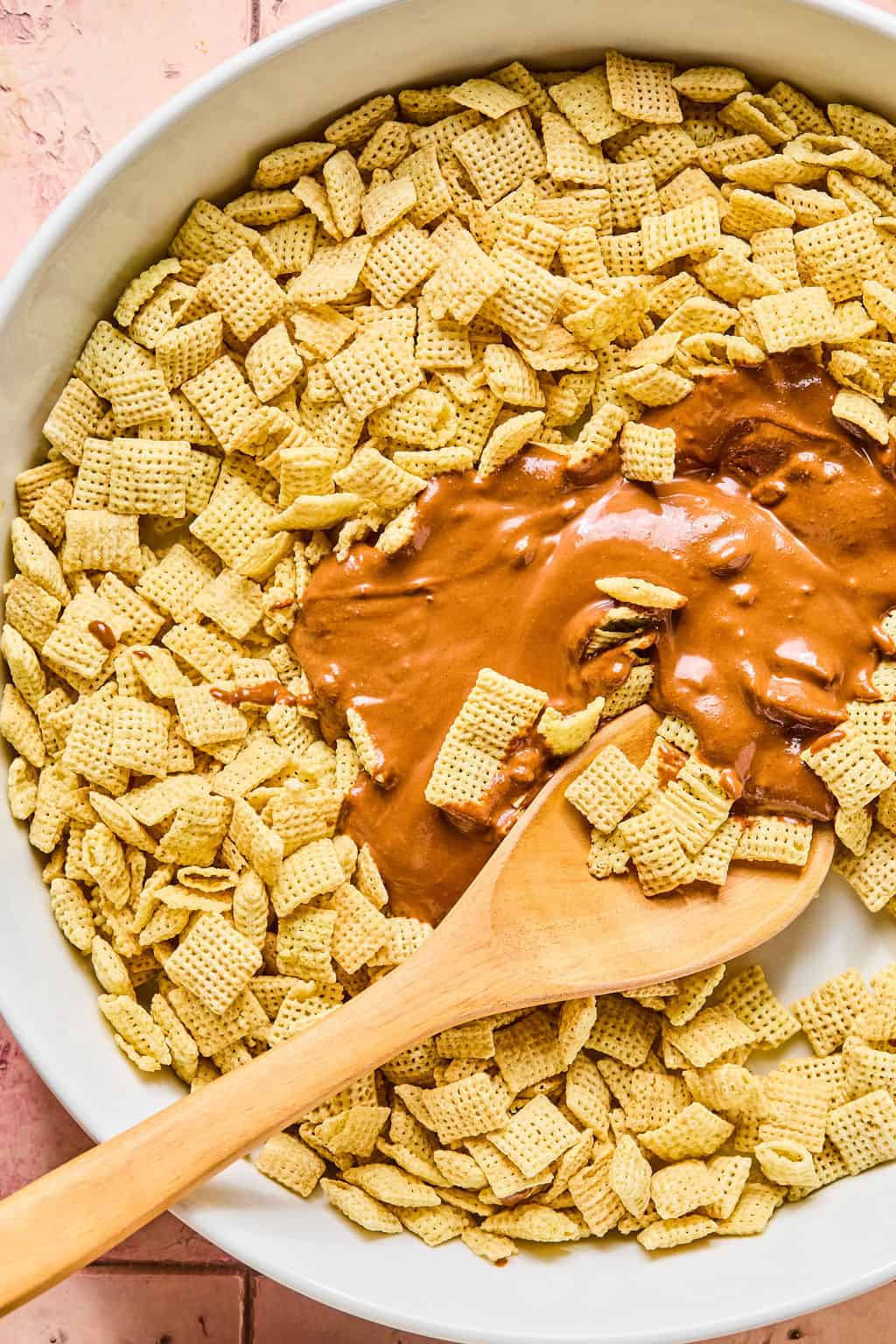 Melted chocolate chips on top of Chex in bowl