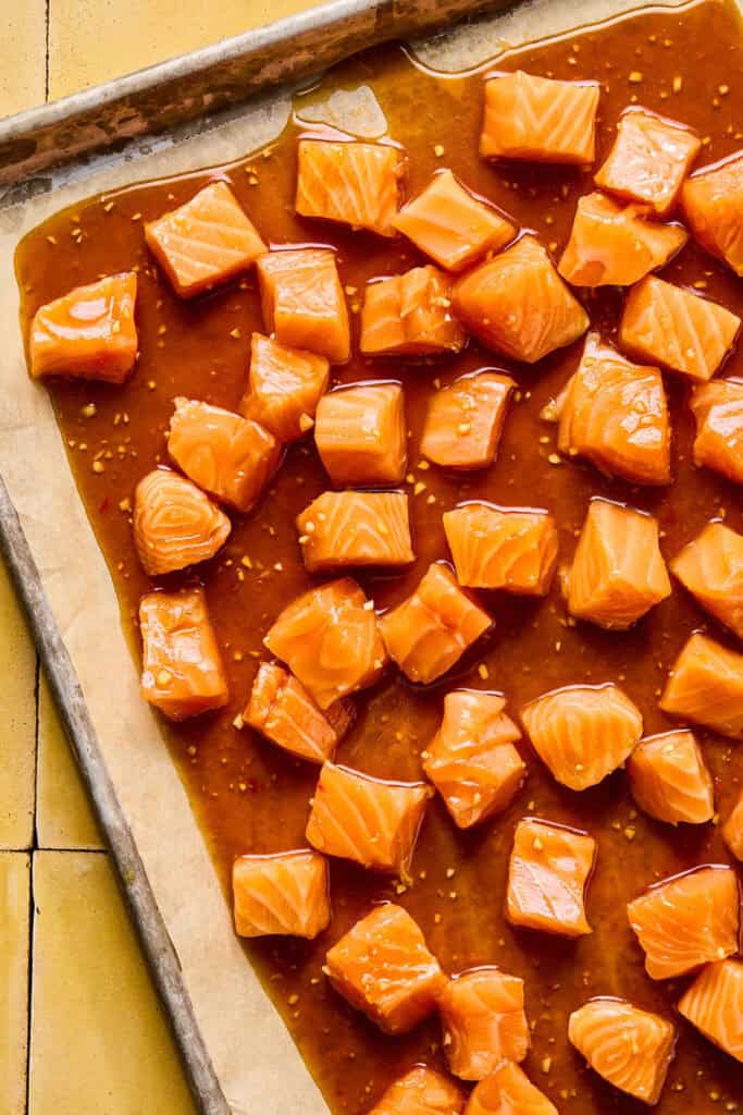salmon cubes and mixture on parchment lined baking sheet