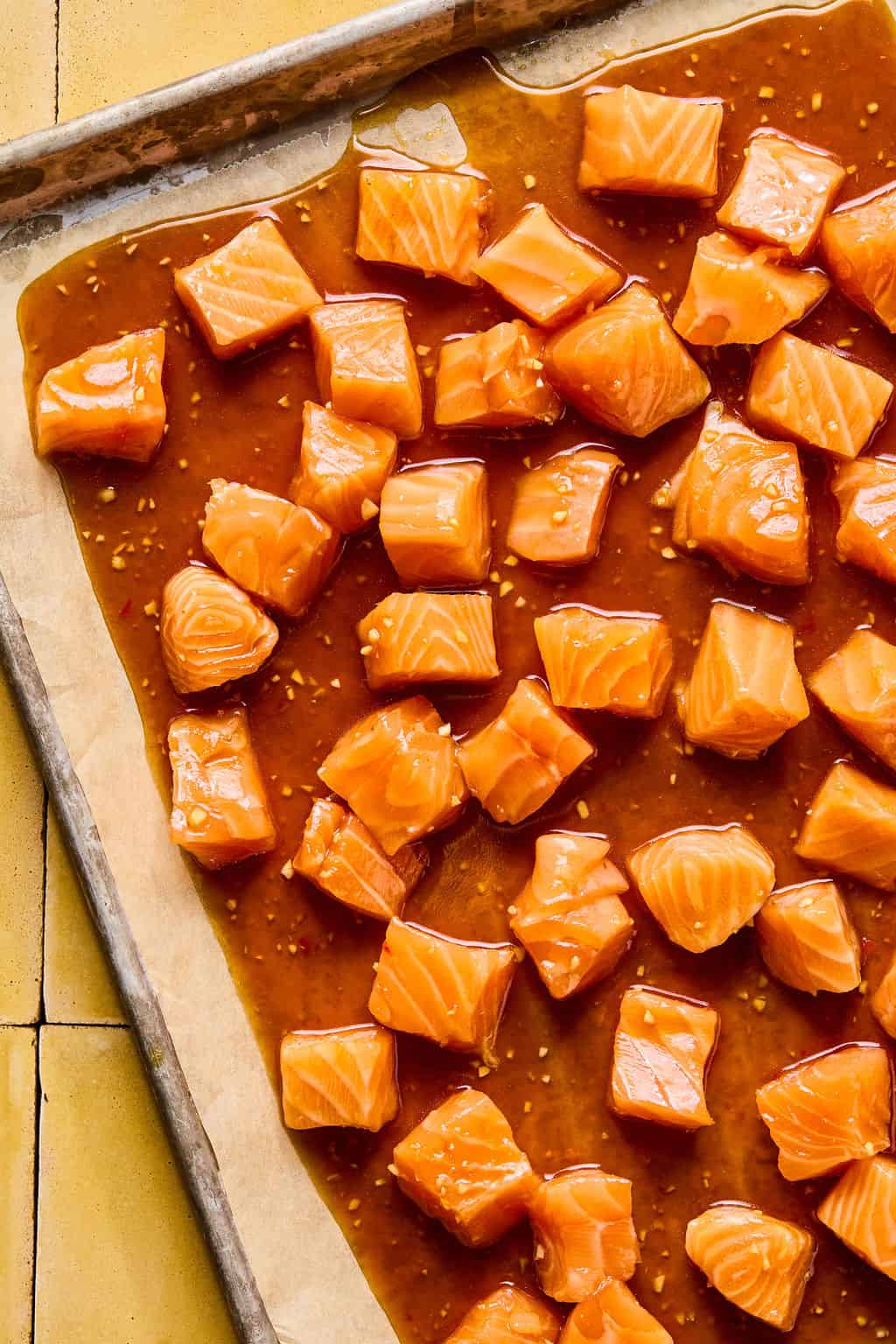 salmon cubes and mixture on parchment lined baking sheet