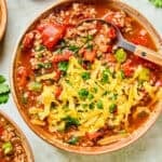 Bowls of stuffed pepper soup topped with shredded cheddar and parsley