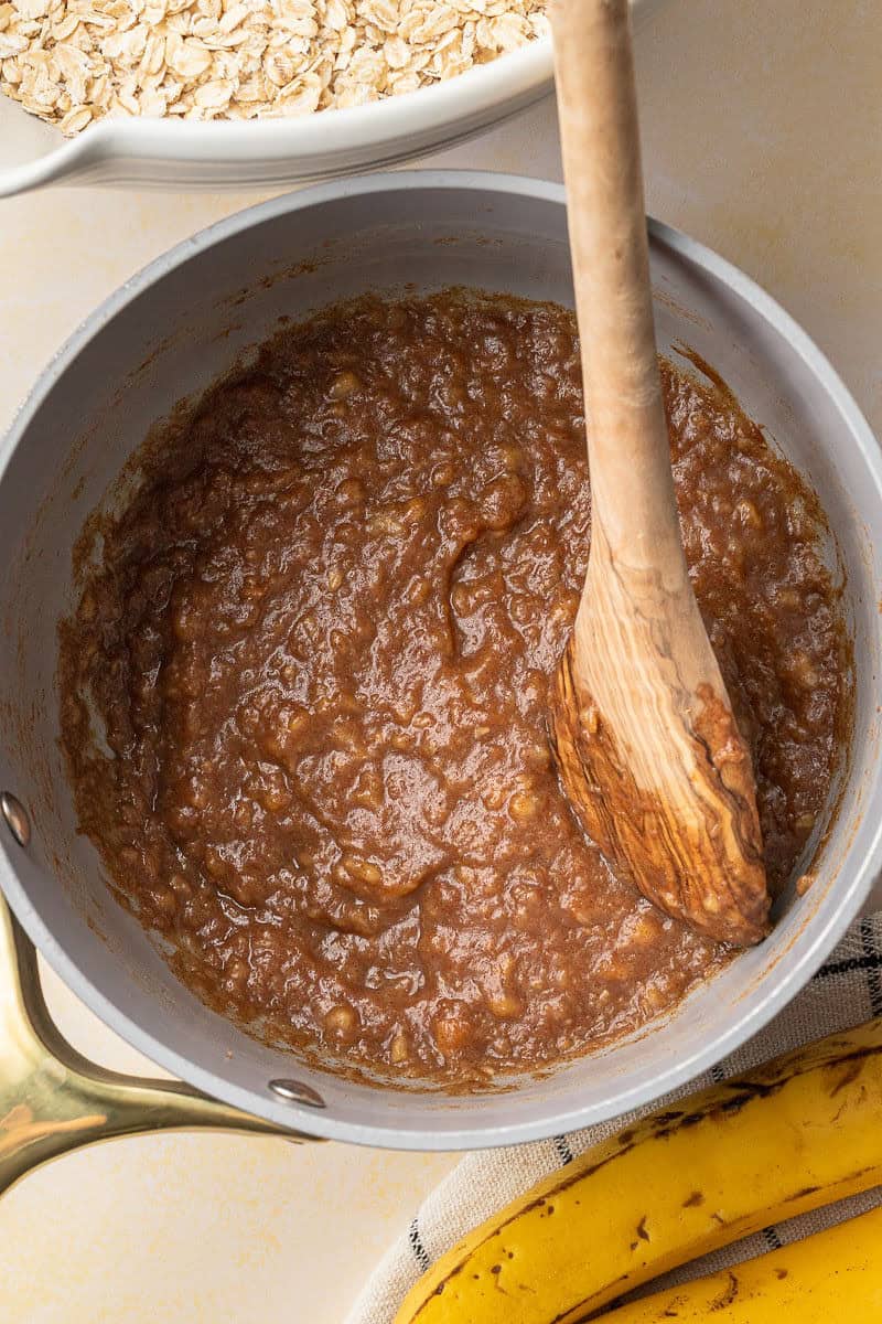 Sauce pot with mashed bananas, cinnamon, maple syrup, and water in it