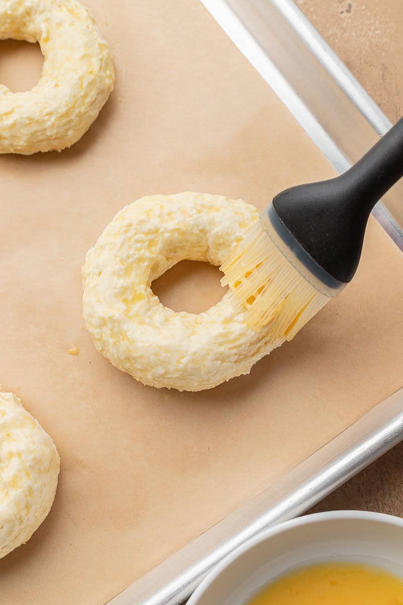 Brushing bagels with egg wash