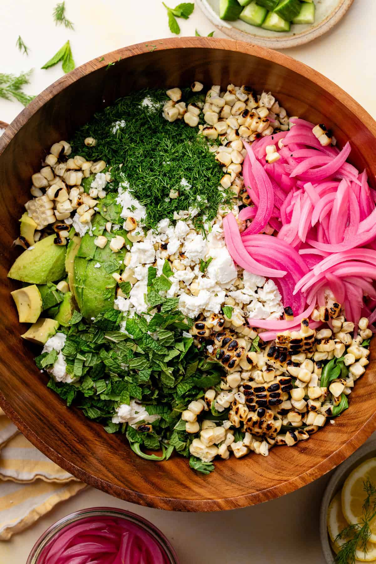 Corn Avocado Feta Dill Salad ingredients in wooden bowl.