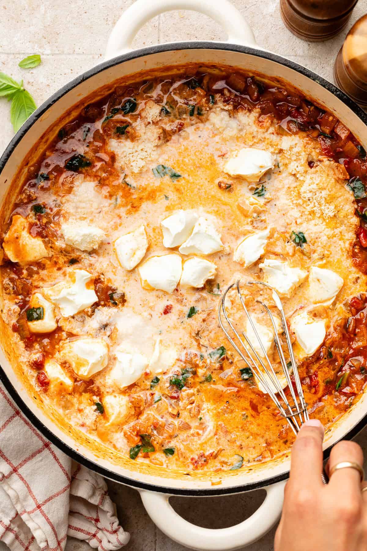 Tomato paste, basil, Italian seasoning, red pepper flake, salt, and pepper, broth and cream cheese in pan.