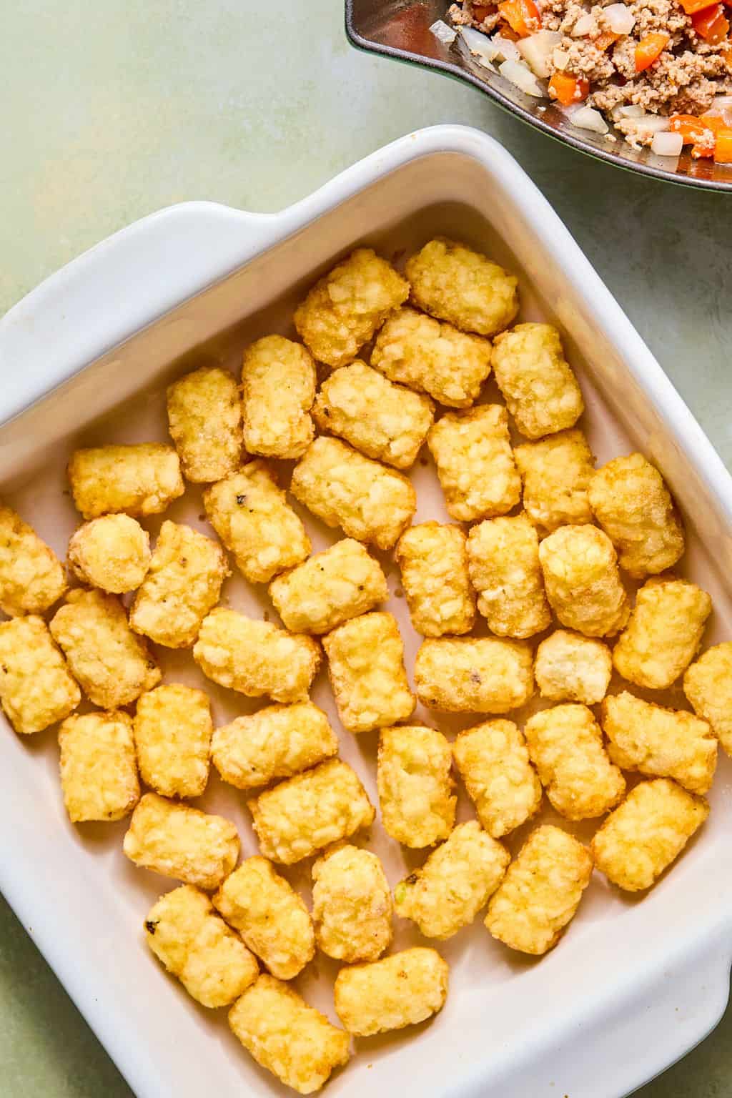 Tater tots in white pan.