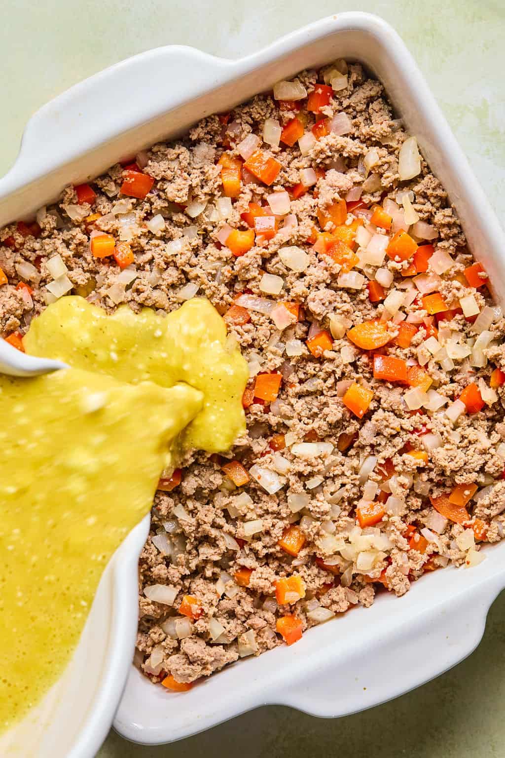 Pouring egg mixture into pan.