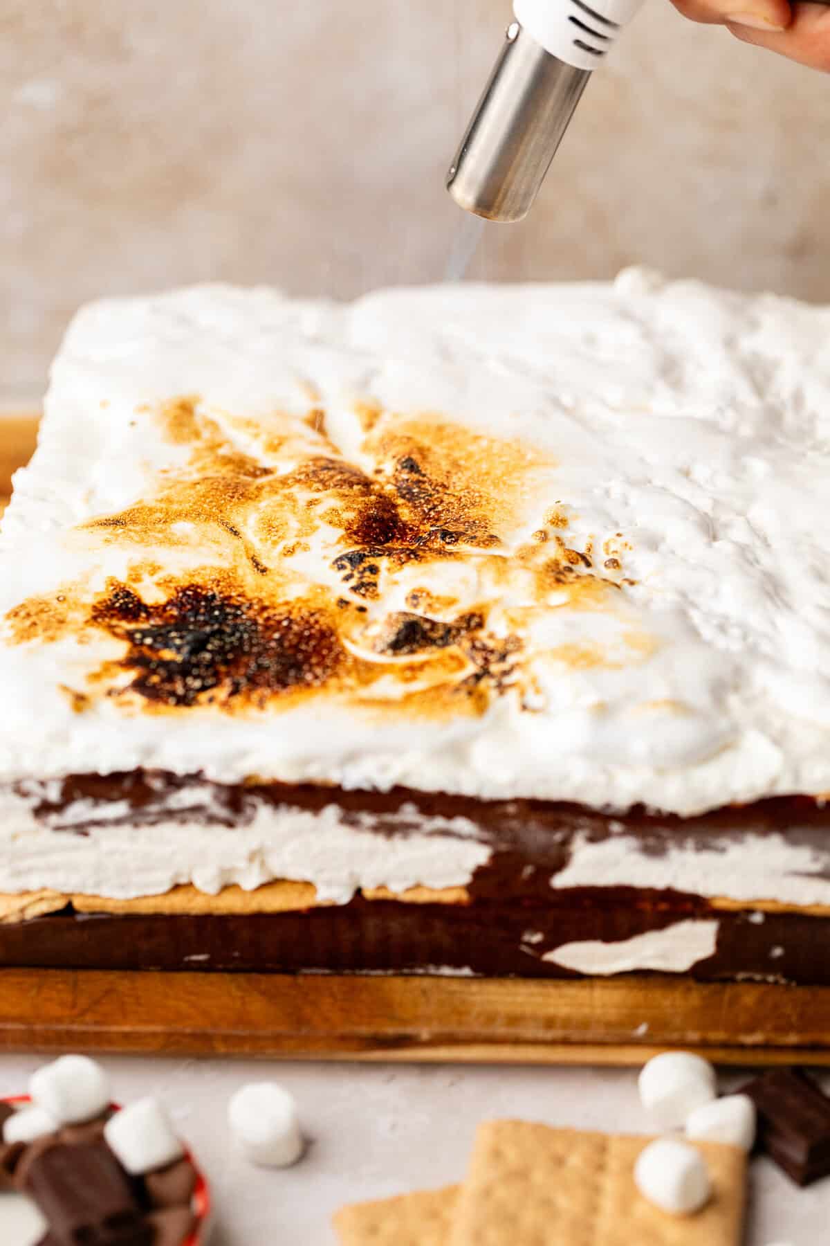 Blow torching top of S'mores Icebox Cake.
