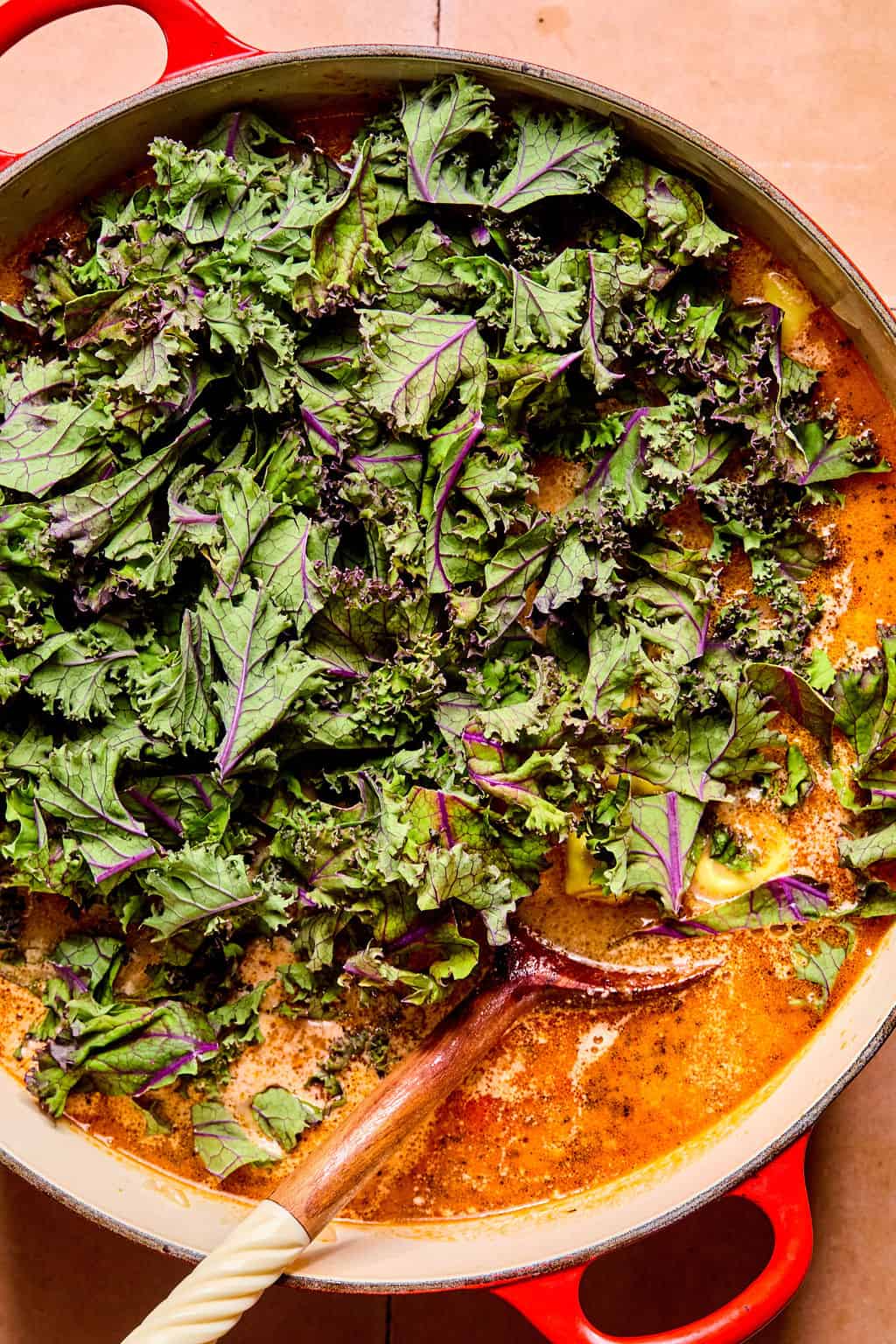 Adding kale to large Dutch oven.