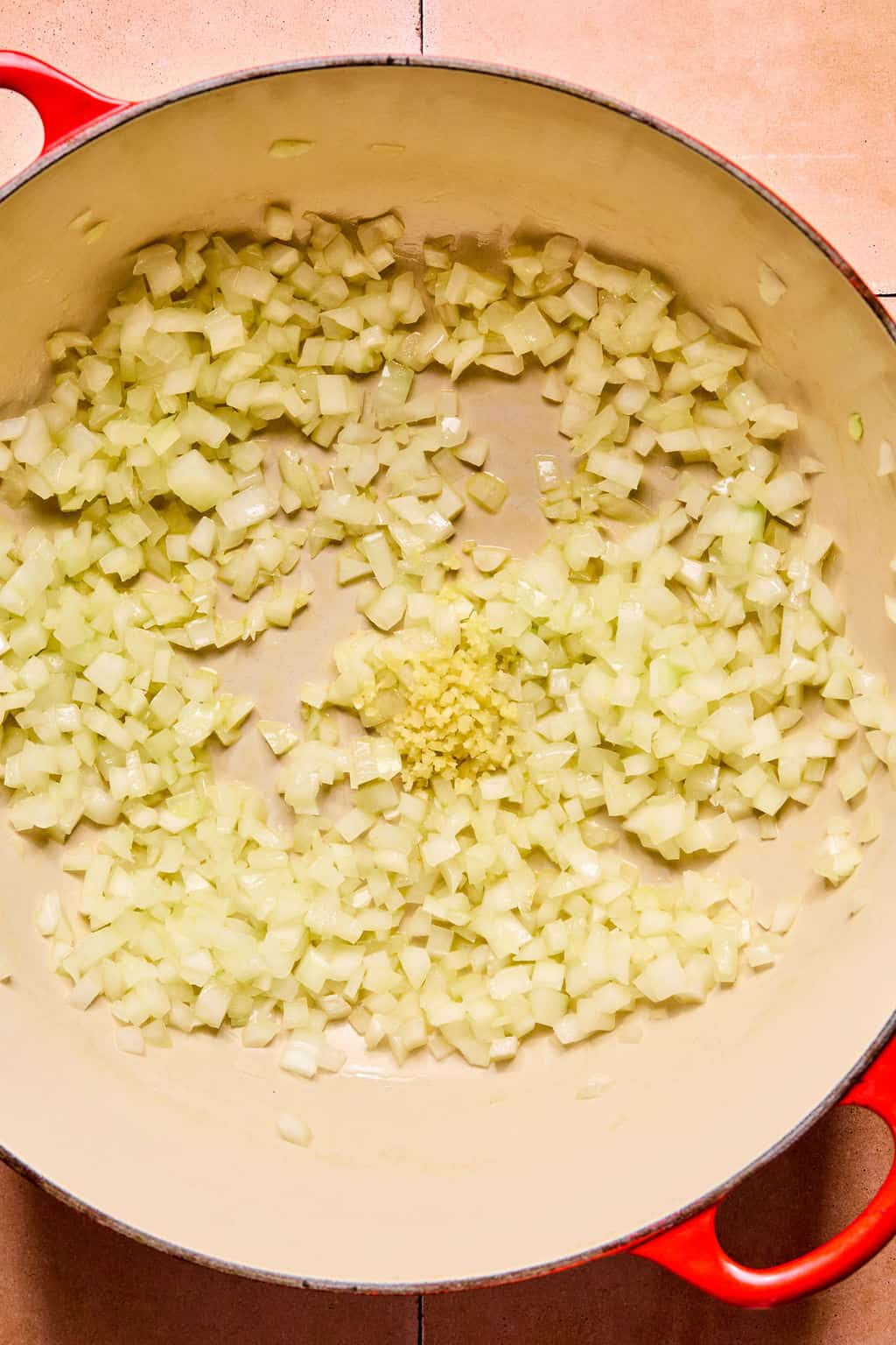 Large Dutch oven with olive oil, onions and garlic.