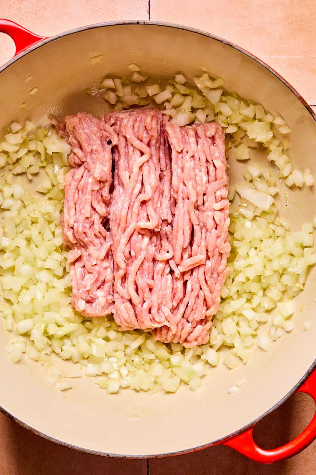 Adding sausage to Dutch oven.