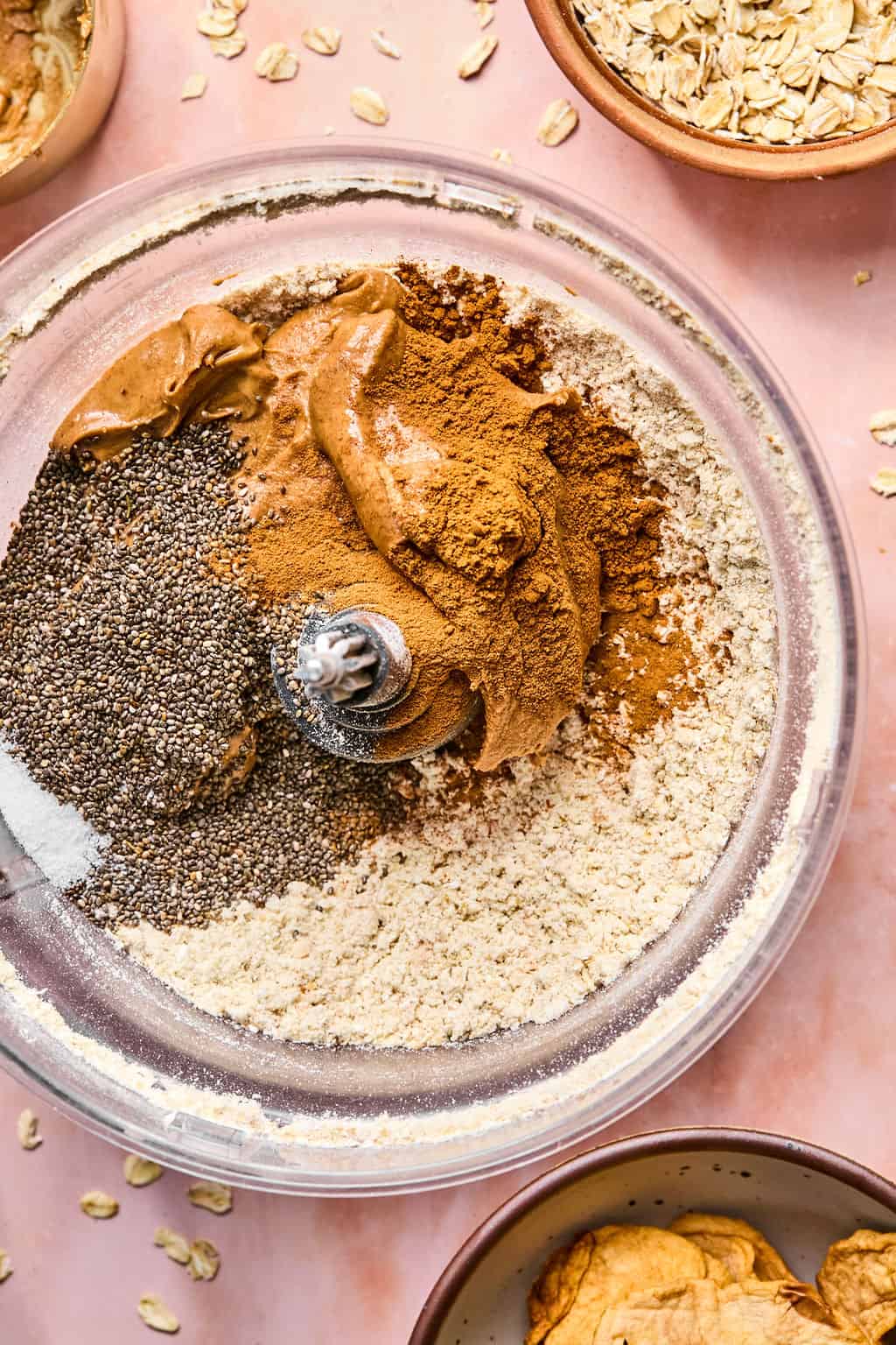 Adding nut butter, chia seeds, apple pie spice, cinnamon and salt into food processor.
