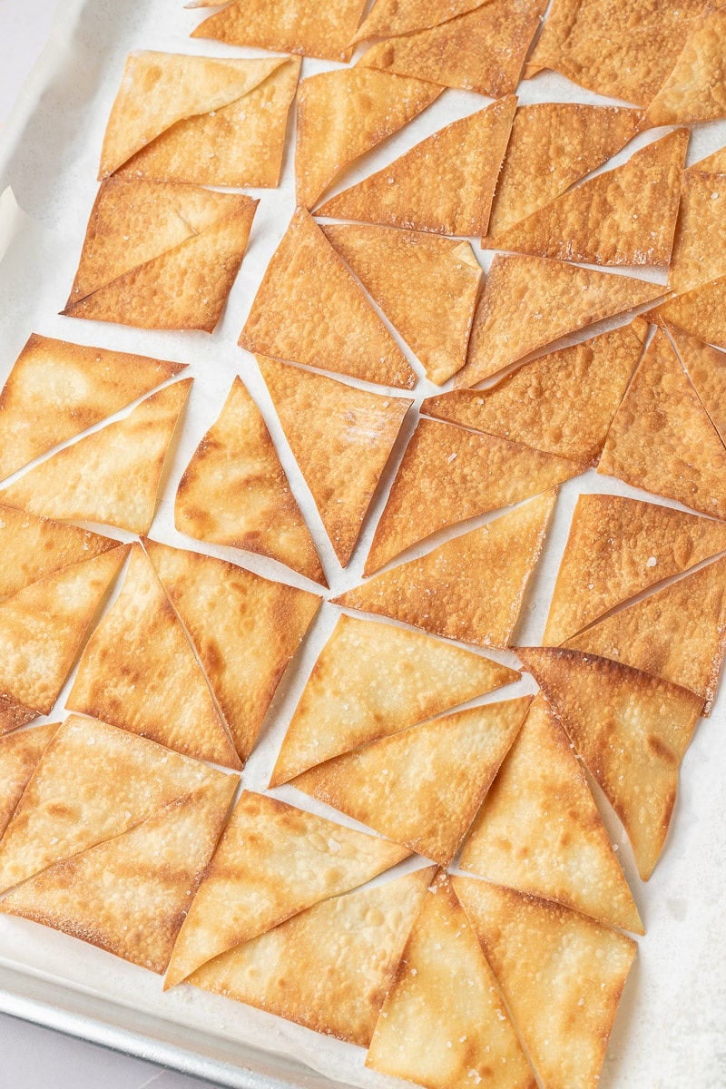 Wonton wrappers cut and on baking sheet.