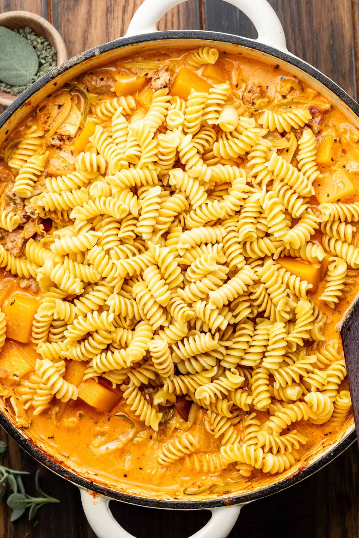 pasta over butternut squash sauce in pan