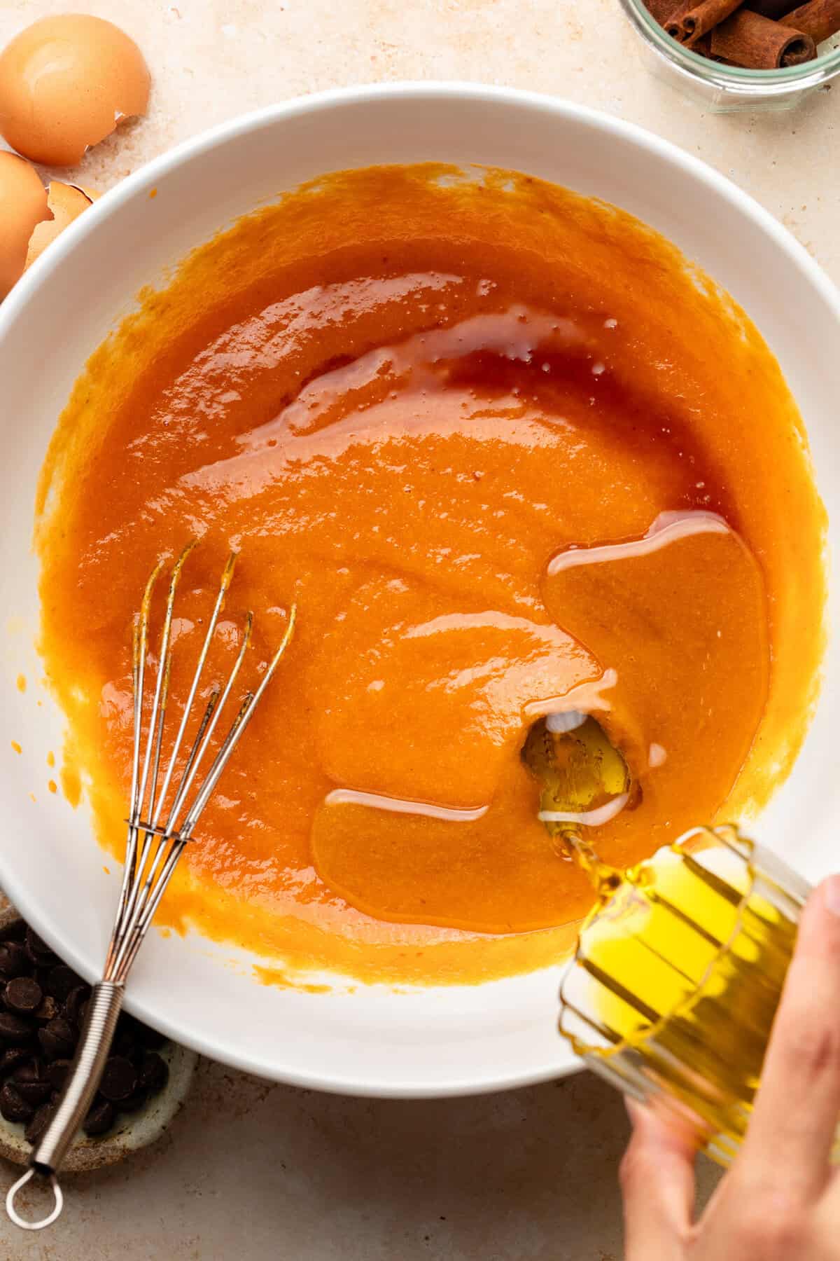 pouring oil into pumpkin olive oil cake batter