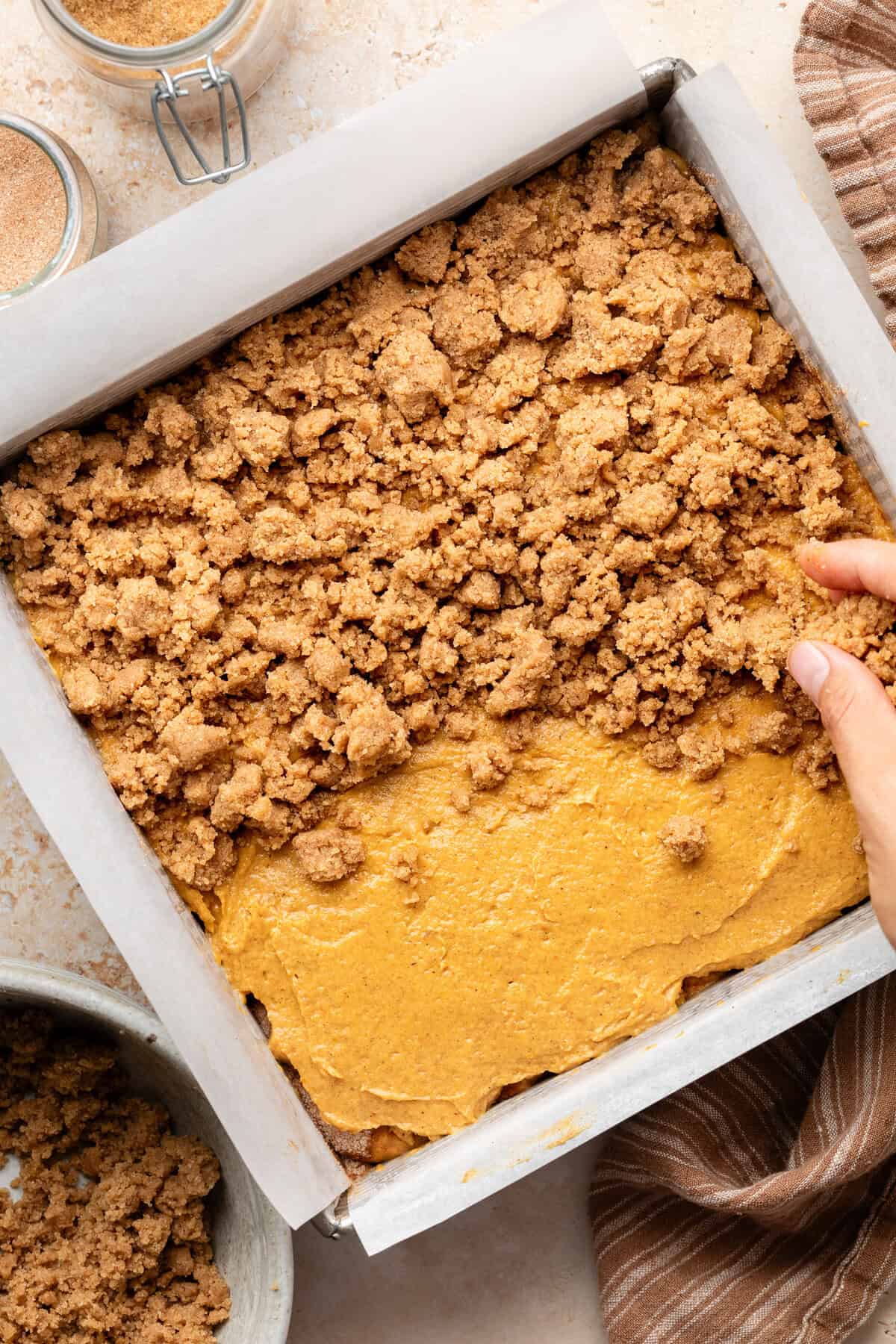 crumbling crumb on top of pumpkin coffee cake batter