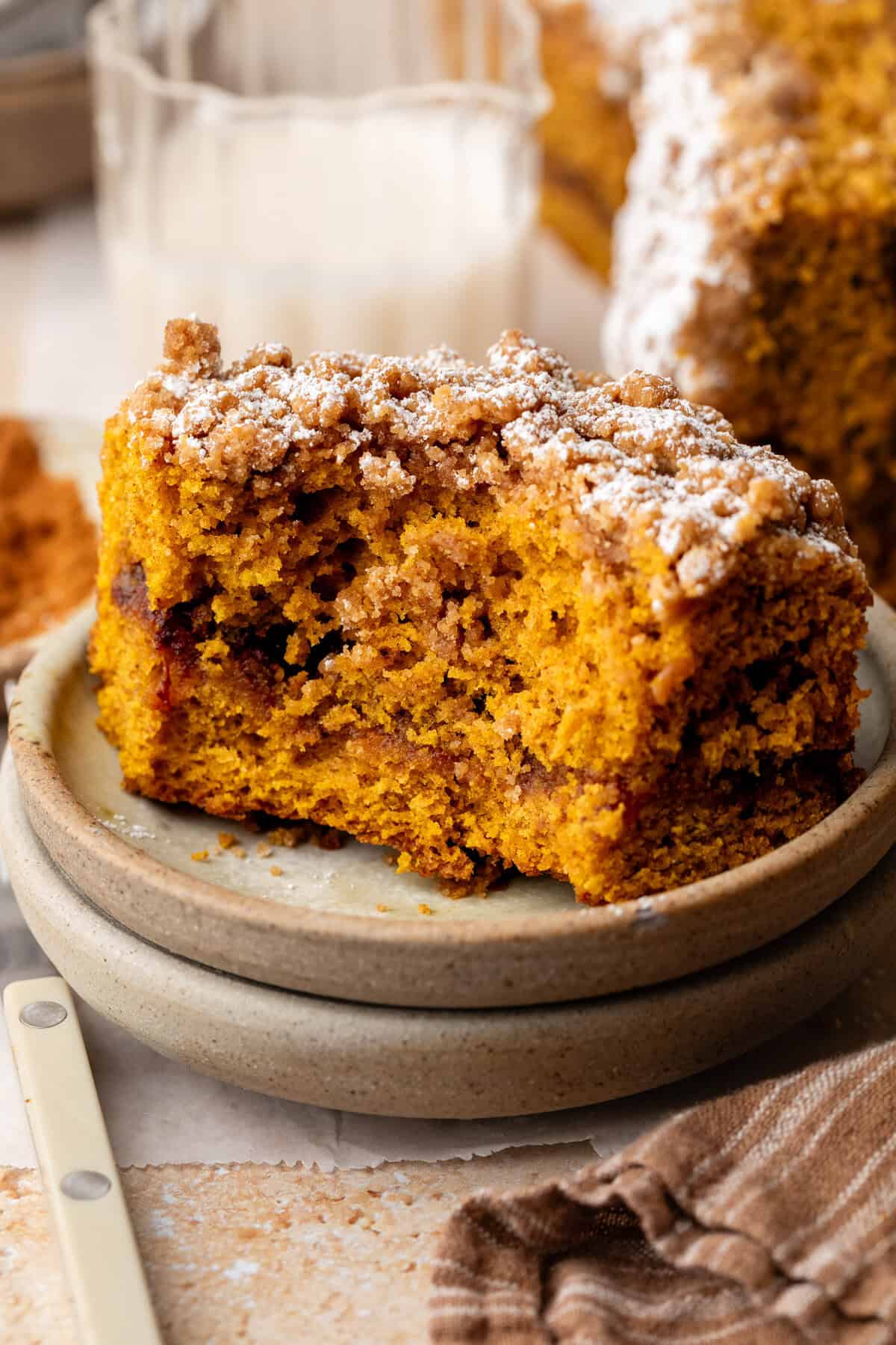 slice of pumpkin coffee cake on plate with bite taken out